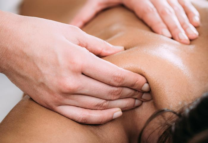 Pressão aplicada com as mãos em regiões de tensão durante massagem terapêutica.
